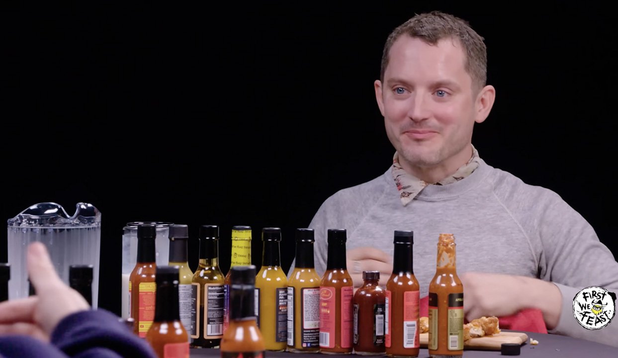 Elijah Wood barely resists the power of the pepper in Hot Ones season 15